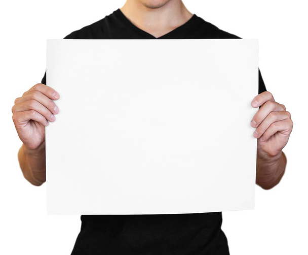 A man holding a white sheet of paper. Holding a booklet. Close u - Zdjęcie, obraz
