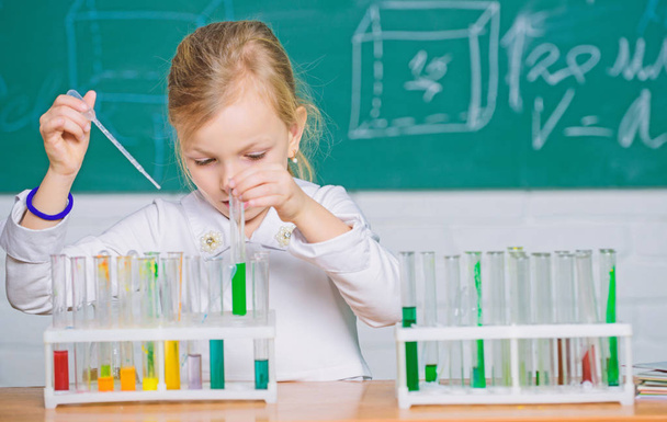 Interesting approach to learn. Future scientist. Explore and investigate. School lesson. Girl cute school pupil play with test tubes and colorful liquids. School chemical experiment. School education - Foto, Bild