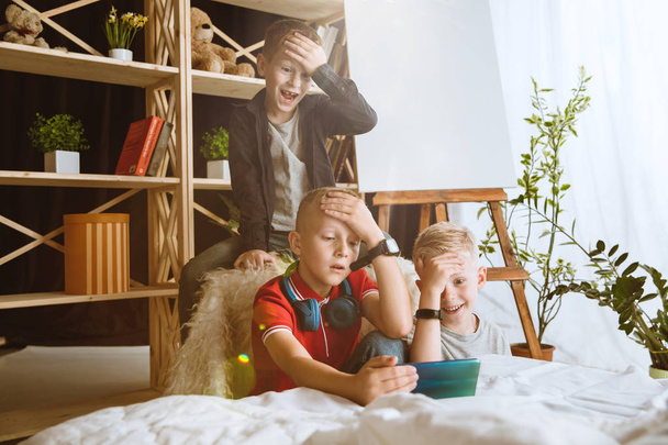 Little boys using different gadgets at home - Foto, Bild