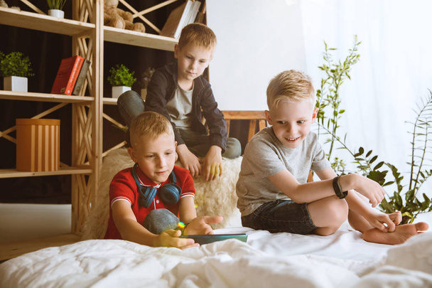 Little boys using different gadgets at home - Fotó, kép