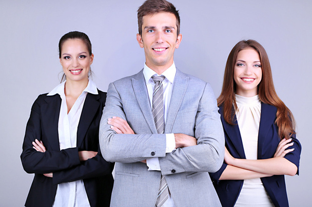 Business team standing in row on grey background - Photo, Image
