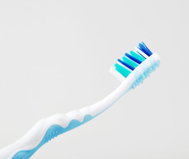 Пластиковая зубная щетка на белом фоне
 - Фото, изображение
