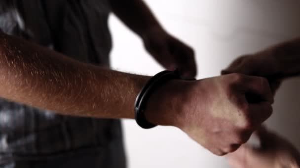 Rendőr teszi a bilincseket a kezébe a büntető - Felvétel, videó