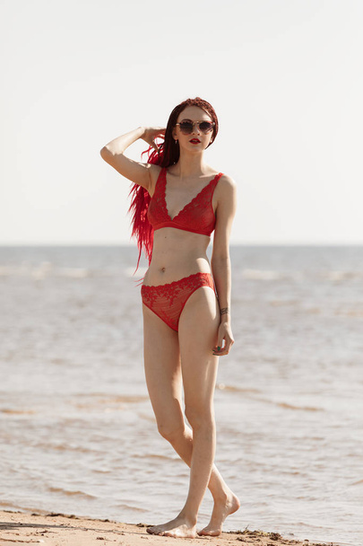 Ragazza in costume da bagno rosso sulla spiaggia
 - Foto, immagini