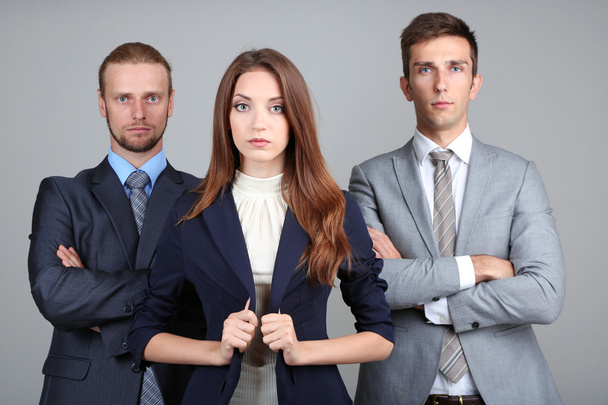 Business team standing in row on grey background - Фото, изображение