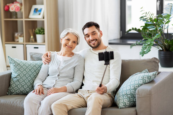 senior mother with adult son taking selfie at home - Foto, Imagen