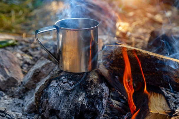 steel cup on an open fire in nature. - Foto, Imagem