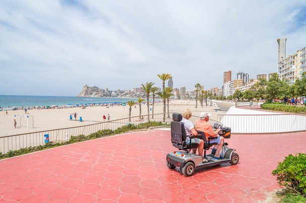 Benidorm, Spain, 17 June, 2019: Senior couple on mobility scooter enjoying summer vacation in Benidorm, Spain - Foto, imagen