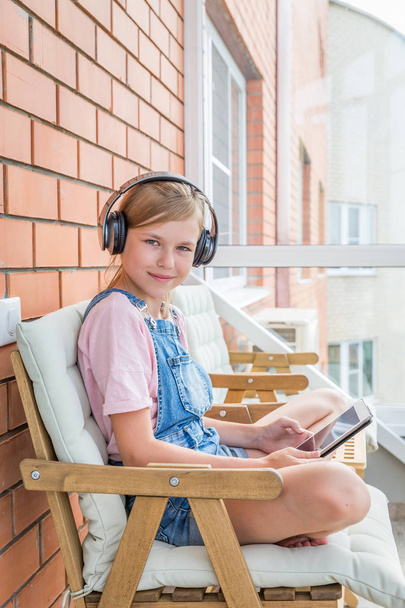 Uma jovem gostando de ouvir música em seu fone de ouvido com tablet
 - Foto, Imagem