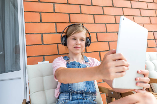 Mladá dívka, která si užívá s tabletem hudbu na sluchátkami - Fotografie, Obrázek