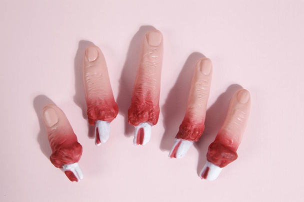gefälschte blutige Plastikfinger rosa Hintergrund - Foto, Bild