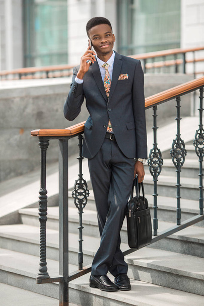 handsome young african man in a suit talking on the phone - Foto, afbeelding