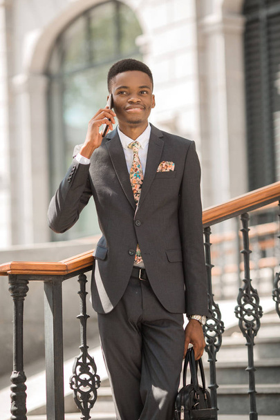 guapo joven africano en un traje hablando por teléfono
 - Foto, Imagen