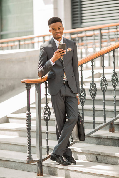handsome young african man in a suit with a phone in his hand - Φωτογραφία, εικόνα