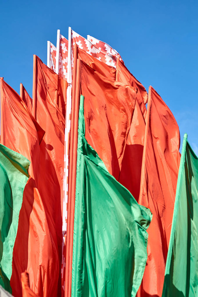 die Flagge der Republik Weißrussland, bestehend aus mehreren Flaggen, gegen den blauen Himmel. - Foto, Bild