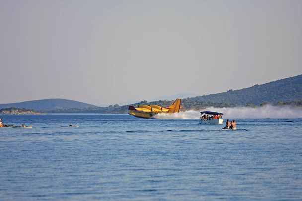 πυροσβεστικό αεροπλάνο που προσγειώνεται στο νερό για να εκπληρώσει τη δεξαμενή του - Φωτογραφία, εικόνα