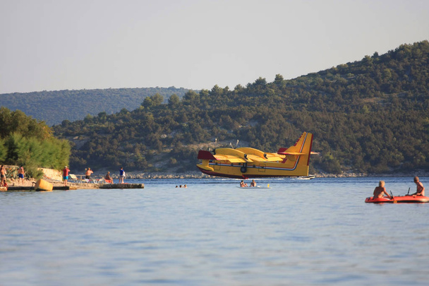 samolot przeciwpożarowy ląduje na wodzie, aby spełnić swój zbiornik - Zdjęcie, obraz
