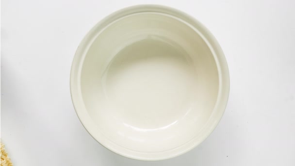 Prepare instant noodle to eat in white ceramic bowl by putting ingredient, pouring boiled water - Πλάνα, βίντεο