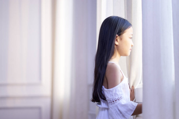 petite fille asiatique regardant par la fenêtre
 - Photo, image