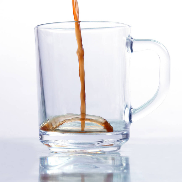 caffè nero viene versato in una tazza trasparente su un backgroun bianco
 - Foto, immagini