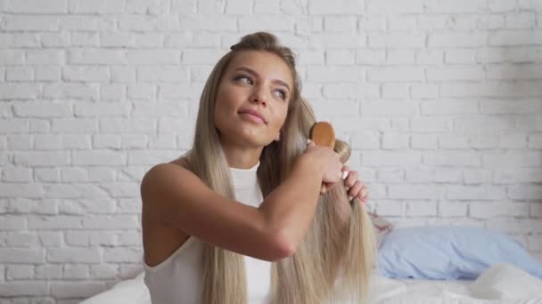 Woman looks desprately at split ends of hair after taking shower. - Materiał filmowy, wideo