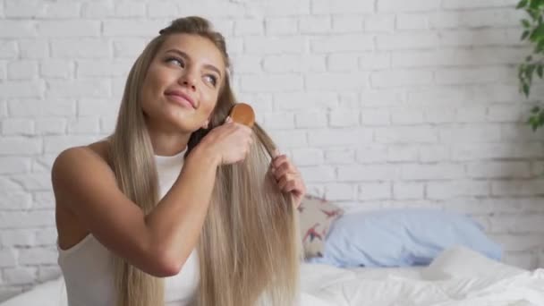 Woman looks desprately at split ends of hair after taking shower. - Záběry, video
