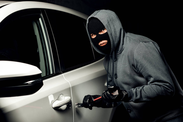 男性泥棒は、クローバーで車のドアを開けるつもりです. - 写真・画像
