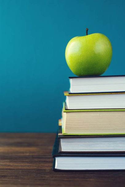 School books with apple on desk - Foto, Bild