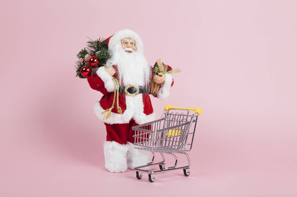 Santa Claus pink background near shopping trolley - Foto, Bild