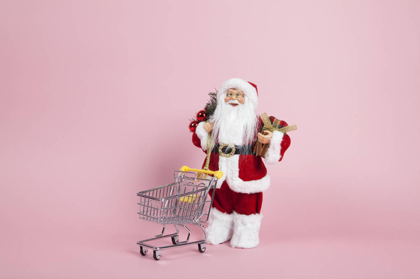Noel Baba pembe arka plan alışveriş arabası  - Fotoğraf, Görsel