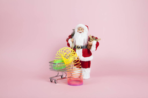 Santa Claus pink shopping trolley with rainbow - Foto, Imagen