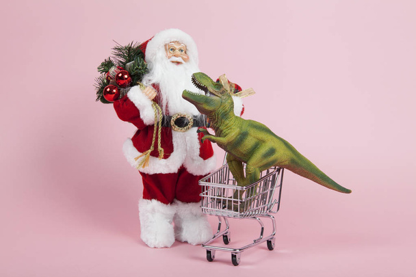 Santa Claus pink shopping trolley with dinosaure  - Φωτογραφία, εικόνα