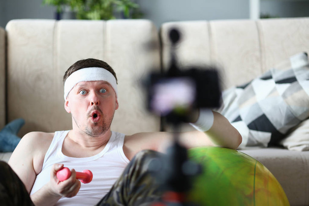 Male vlogger holds dumbbells in his - Φωτογραφία, εικόνα