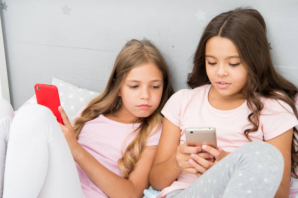 Mobile addicted. Girl play games smartphone online. Pajamas party concept. Happy childhood. Kids surfing internet mobile application social networks. Modern children living online life mobile phones - Foto, immagini