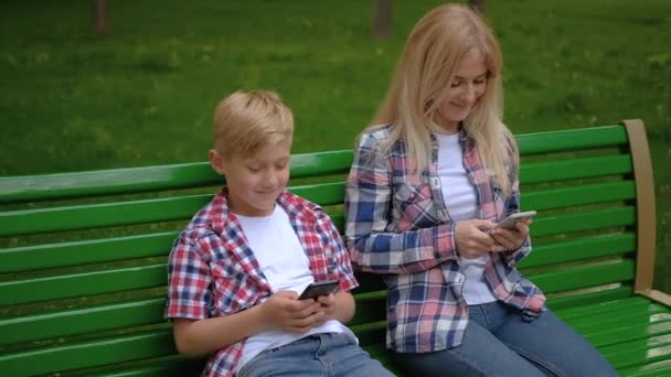 texting communication mom son sitting bench phone - Felvétel, videó