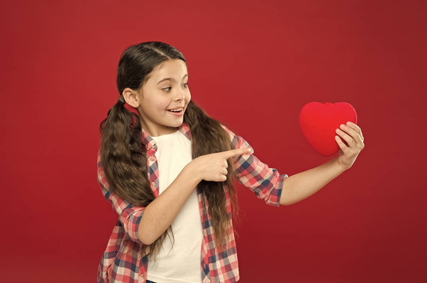 Look at this big heart. Cute girl in love. Having heart problem and heartache. Happy valentines day. Little girl pointing finger at red heart. Little child expressing love on valentines day - Fotó, kép