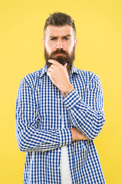 Needing a barber to shape the beard. Bearded man thinking of visiting barber. Thoughtful hipster touching unshaven chin before going to barber shop. Trimming a beard like a master barber - Фото, изображение