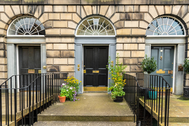 Portas exteriores de madeira britânicas tradicionais de um edifício residencial de pedra
 - Foto, Imagem