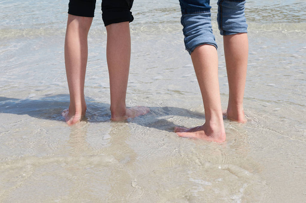 Feet of 2 kids at the sea shore - Fotó, kép