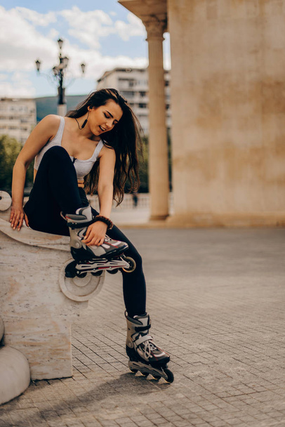 woman put on rollers for roller-skating in the down town - Foto, Imagen
