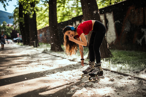 Parkta dikilirken ve dinlerken silindirleri bağlarken kadın - Fotoğraf, Görsel