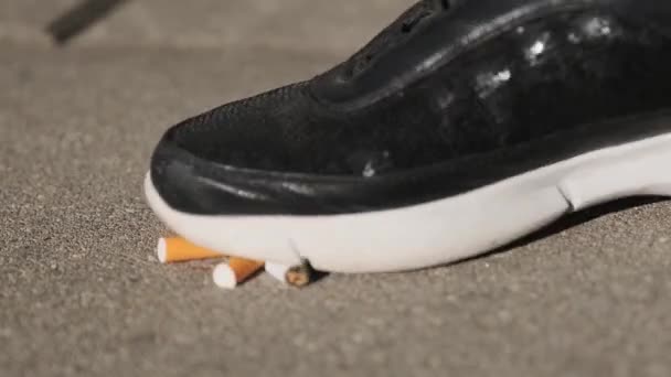 a woman tramples cigarettes on asphalt, stop smoking, quit smoking - Filmagem, Vídeo