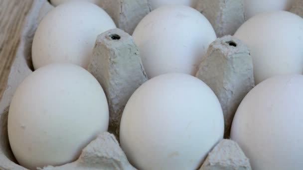 Τα λευκά αυγά κοτόπουλου είναι φρέσκα, στοιβάζονται σε οικολογική συσκευασία από χαρτόνι. Φόντο φαγητού. Γκρο πλαν. - Πλάνα, βίντεο