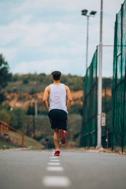 Man jogging on a racing track - Foto, Bild