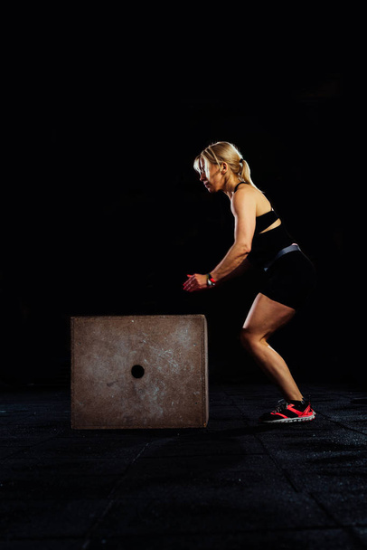 Γυναίκα κάνει άλματα κουτί στο γυμναστήριο, έντονη προπόνηση - Φωτογραφία, εικόνα