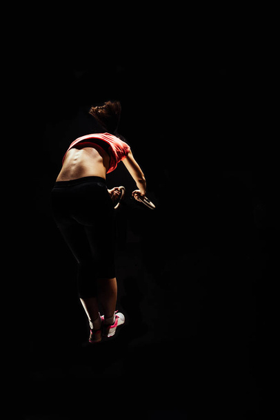 Кольца тренировки женщина в тренажерном зале висит в кроссфит спортзал
 - Фото, изображение