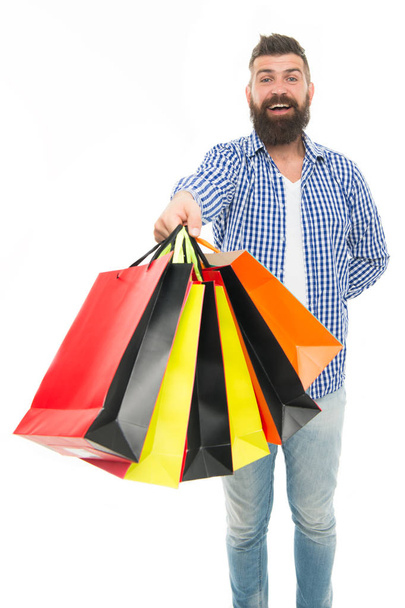 A zsákok megtelnek. Boldog csípő vásárló gazdaság bevásárló táskák elszigetelt fehér. Szakállas férfi mosolyogva papír táskák után szezonális értékesítés. Nyaralási vásárlások színes zsákokban - Fotó, kép