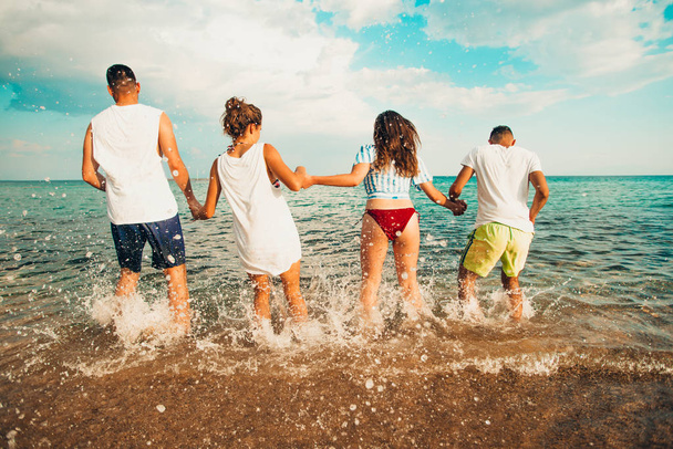 Группа счастливых друзей, прыгающих в воду летом
 - Фото, изображение