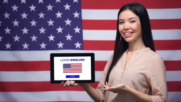 Lady trzymając tablet z nauki angielskiego App, USA Flaga na tle, edukacja - Materiał filmowy, wideo