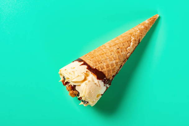 緑の背景にピーナッツとトップビューマンゴーとチョコレート風味のアイスクリームコーン - 写真・画像